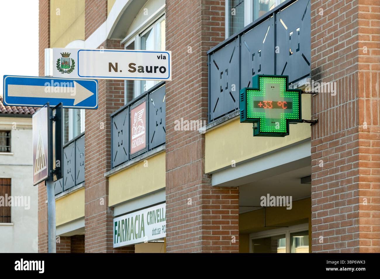 Piove di Sacco, Padua, Veneto, Italien - 4. Juli 2025: Das Kreuzzeichen der Apotheke zeigt 33 Grad Celsius an einem heißen Sommertag an Stockfoto