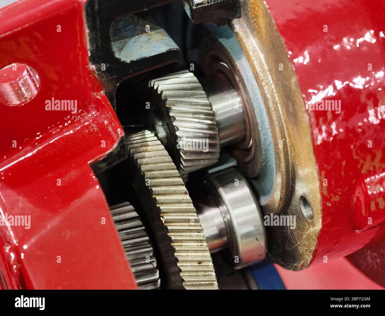Komplizierte Getriebe und Mechanismen in einem leuchtend roten Motor, der die technische Kompetenz und das handwerkliche Können der Maschinen unterstreicht Stockfoto