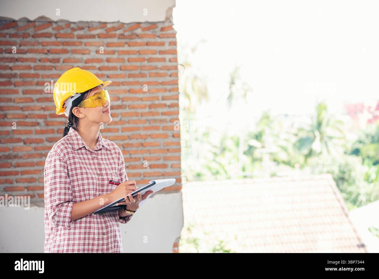 Bauingenieurin trägt einen weißen Schutzhelm bei Baustellenarbeitern. Ingenieurin mit Schutzhelm sa Stockfoto