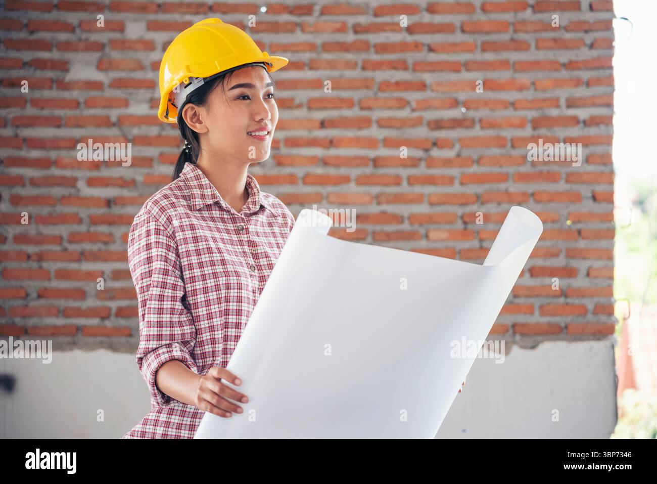 Bauingenieurin trägt einen weißen Schutzhelm bei Baustellenarbeitern. Ingenieurin mit Schutzhelm sa Stockfoto