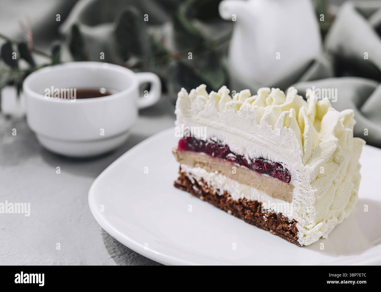 Essen, Mousse-Kuchen auf weißem Teller und Tasse Tee Stockfoto