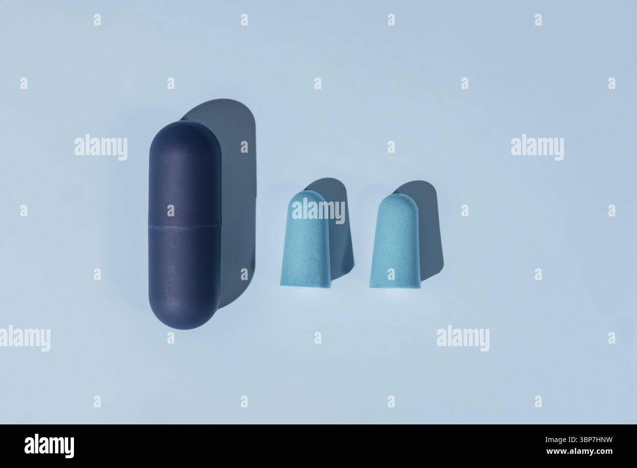 Blauer Ohrstoepsel aus Schaumstoff für bequemen Schlaf auf blauem Hintergrund. Schlaflosigkeit Konzept, flach legen Stockfoto