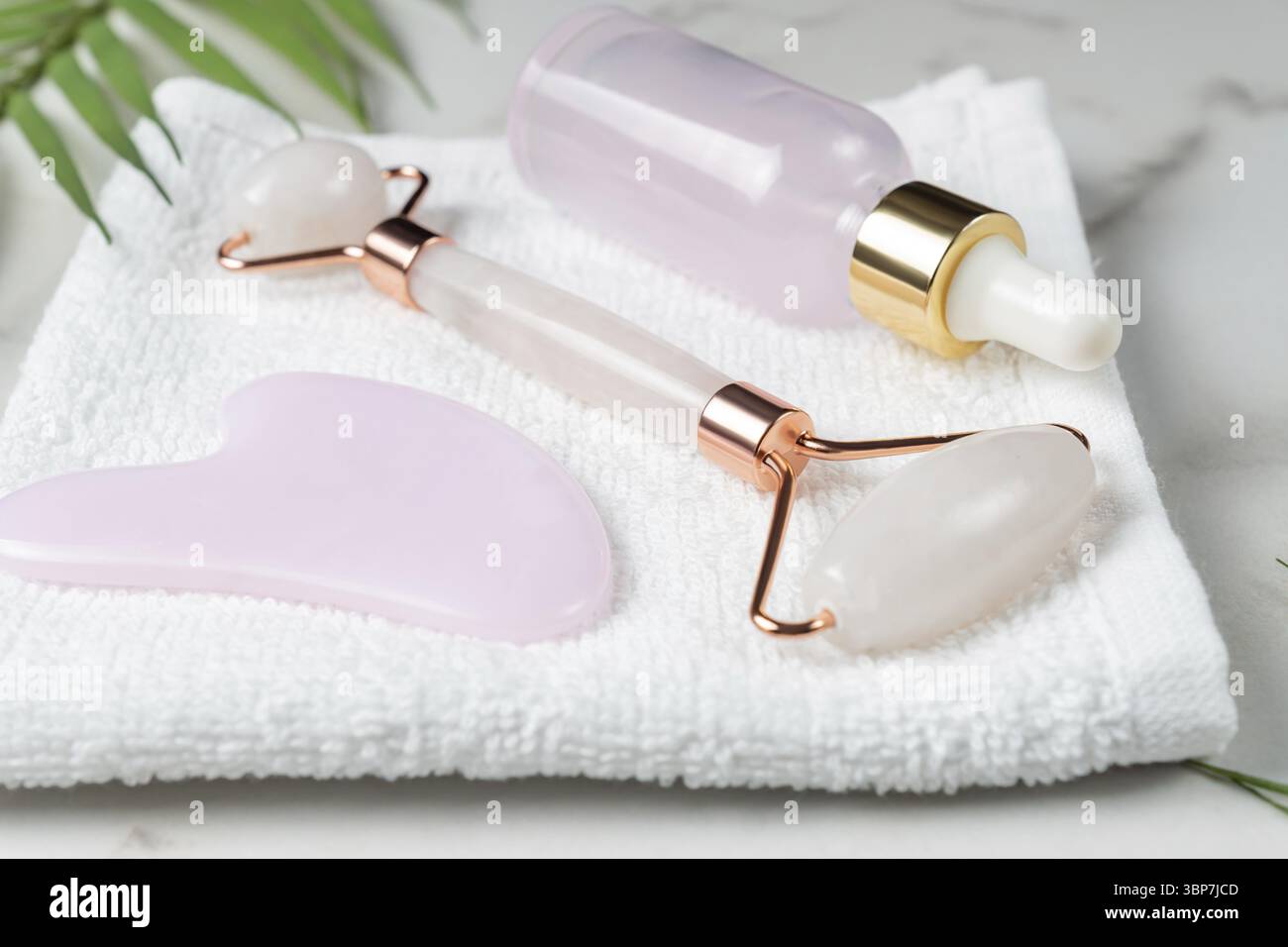Rosa Roller Face Massagegerät Guasha Scraper. Jade Stone Gesichtsmassager für Gesicht und Körper mit Tropfflasche aus Beauty-Serum. Trendiges Modekonzept. Anti Stockfoto