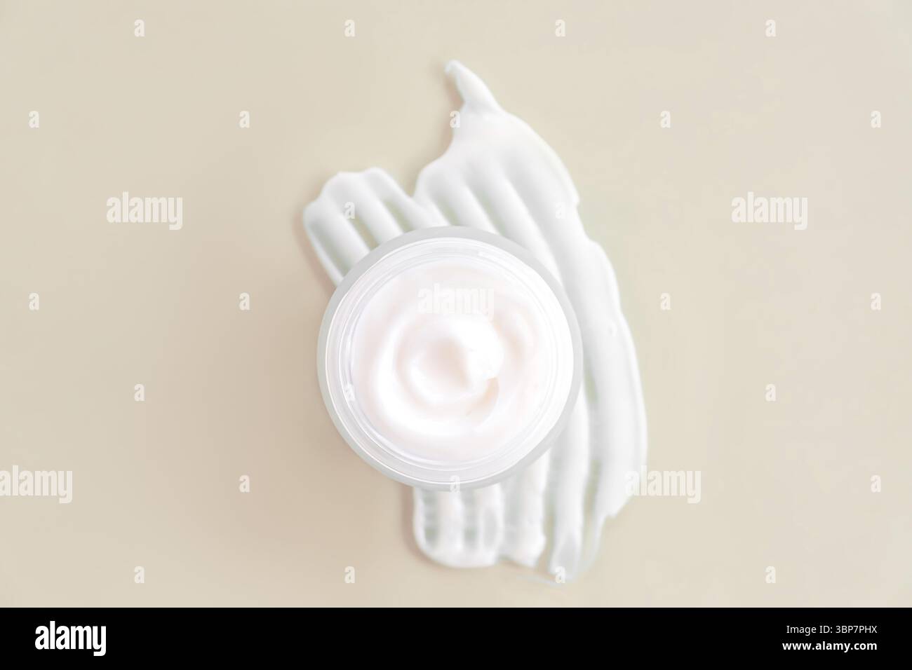 Hautpflege Kosmetik Creme oder Lotion Swatch Swidge auf beigefarbenem Hintergrund. Weißes cremiges Kosmetikprodukt in einem Glas. Flache Ladefläche, Kopierraum Stockfoto