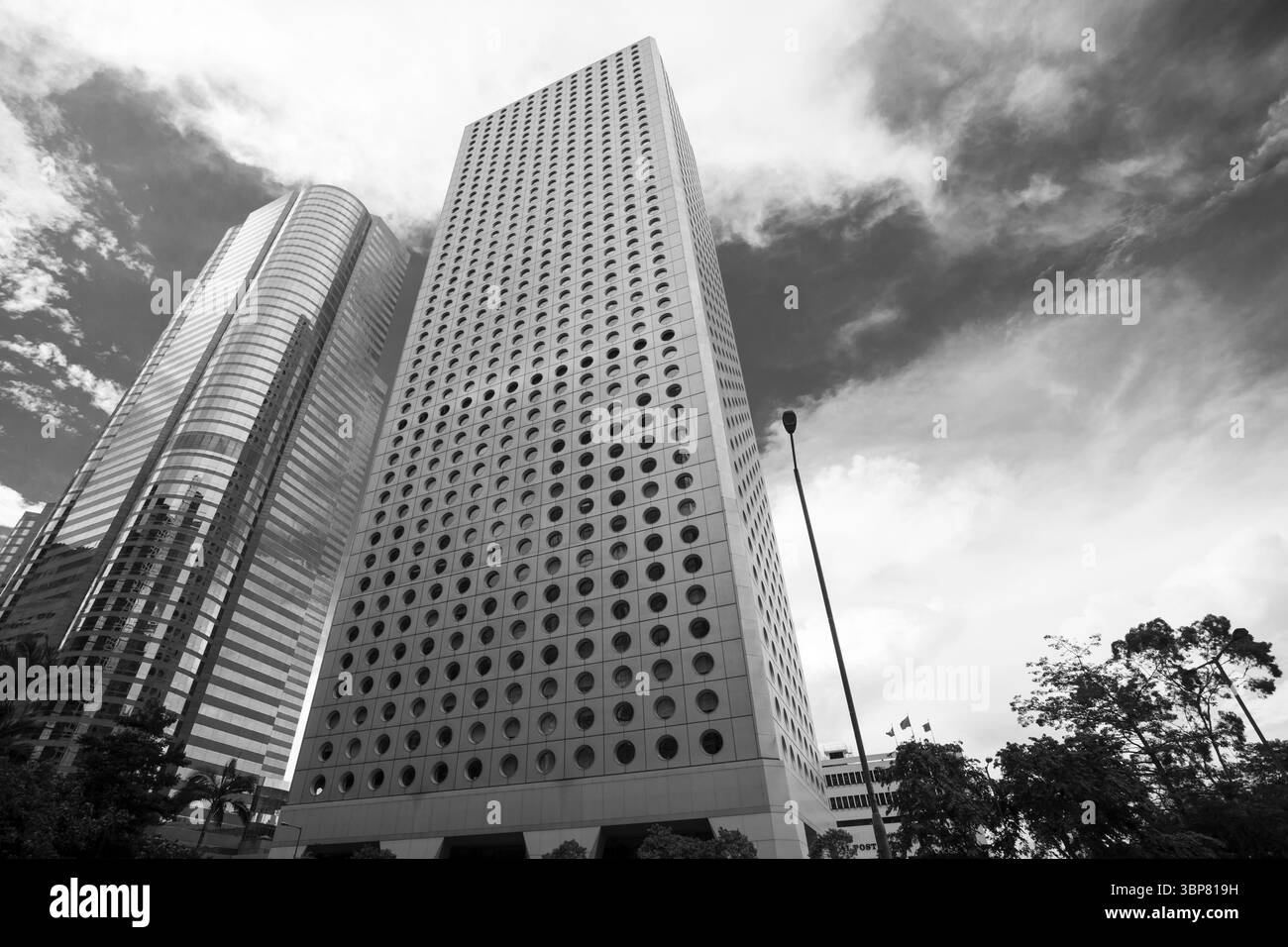 Hongkong - 15. Juli 2017: Schwarzweiß-Fotografie, die eindrucksvolle zeitgenössische Wolkenkratzer mit unverwechselbarem Design unter einem malerischen bewölkten Himmel einfangen Stockfoto