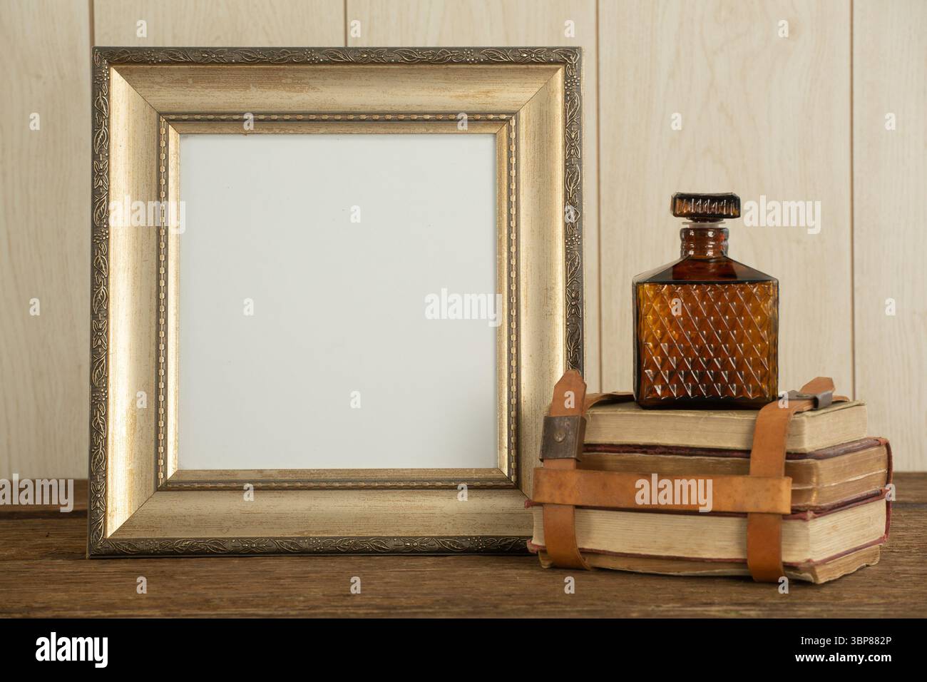 Bilderrahmen, Parfüm und Buchstapel auf dem Tisch Stockfoto