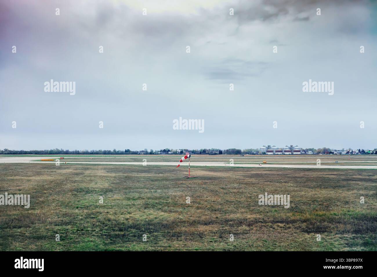Windsocke auf dem Flugplatz. Rot-weiß fliegende Anemometer zur Anzeige der Windrichtung und -Geschwindigkeit auf der Grasebene in der Nähe der Start- und Landebahn. Windsockungsanzeige am Flughafen Stockfoto