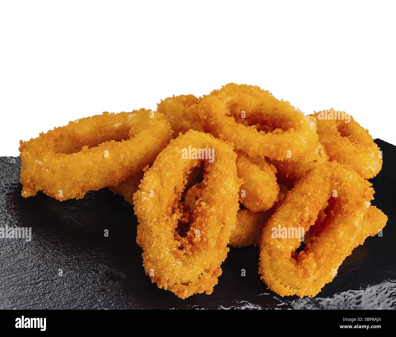 Speisen, frittierte Calamari-Ringe mit knuspriger goldener Panade werden auf einem schwarzen Schieferteller serviert Stockfoto