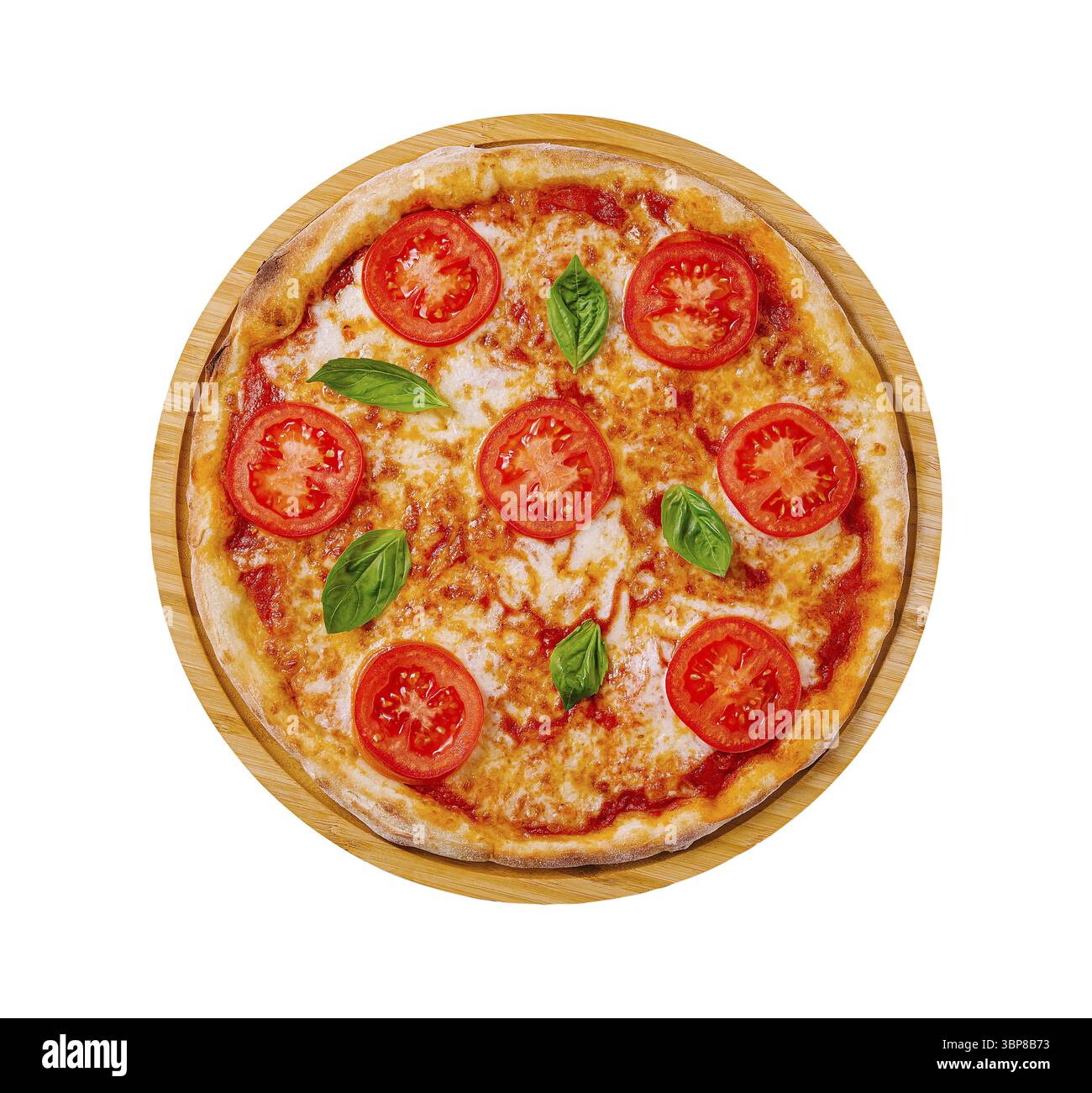 Essen, Eine runde Pizza, frisch gebacken, mit Tomatenscheiben und lebhaften Basilikumblättern auf klassischem Käsebasis, präsentiert auf einer hölzernen Servierplatte Stockfoto