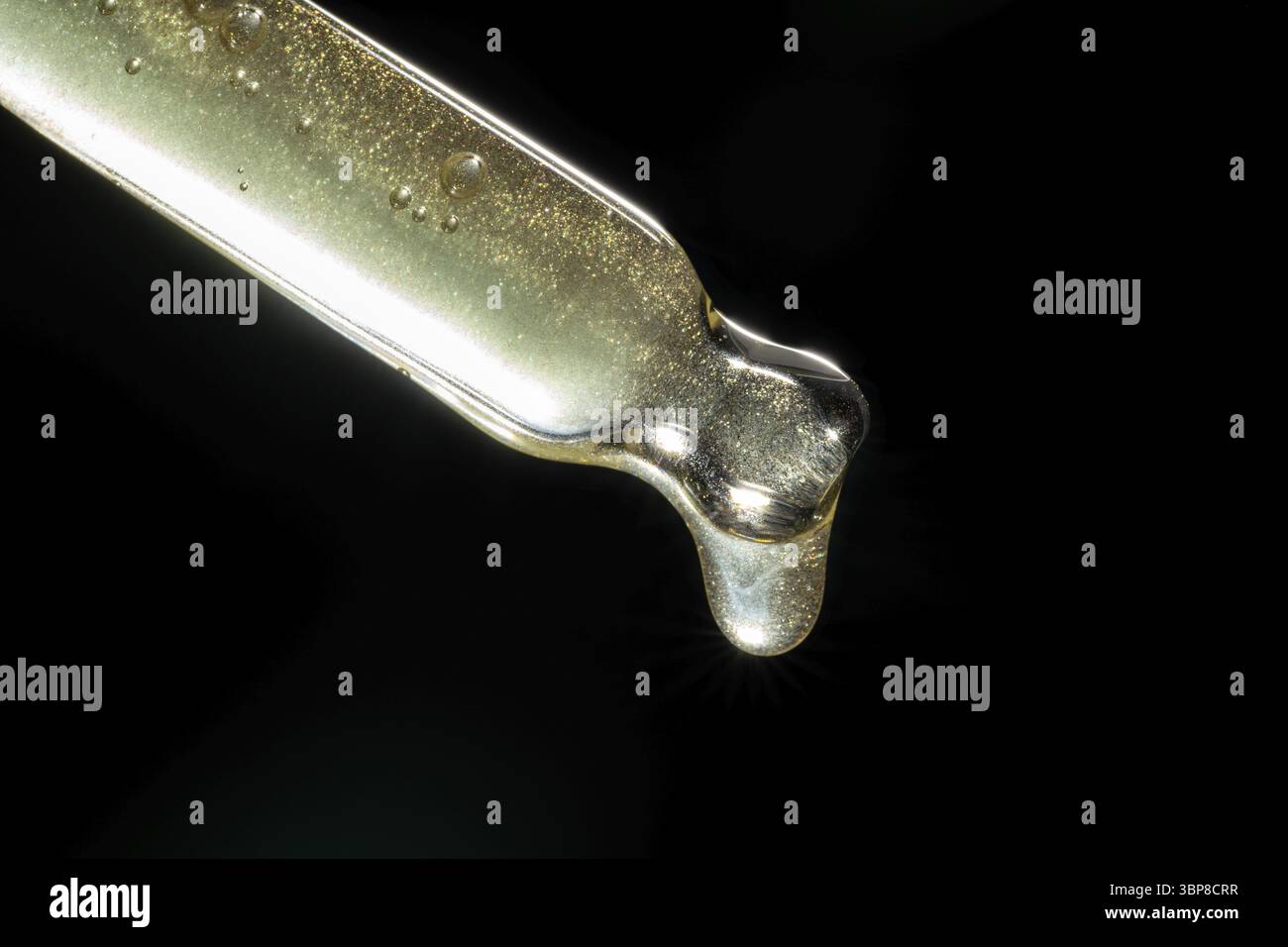 Schönheitshintergrund mit Pipette und Flüssigpflegeprodukt. Tropfer mit goldenem Serum, Emulsion, Hyaluron auf schwarzem Hintergrund Stockfoto