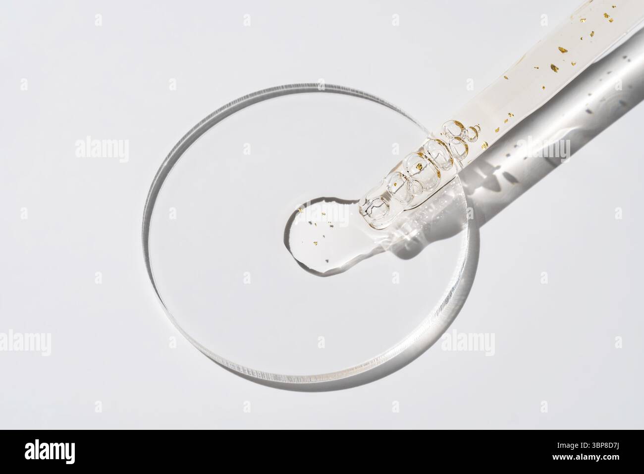 Kosmetische Pipette mit 24-karaetigem Goldoel auf weissem Hintergrund in der Großaufnahme. Stilvolles Konzept von Bio-Essenzen, Schönheits- und Gesundhe Stockfoto