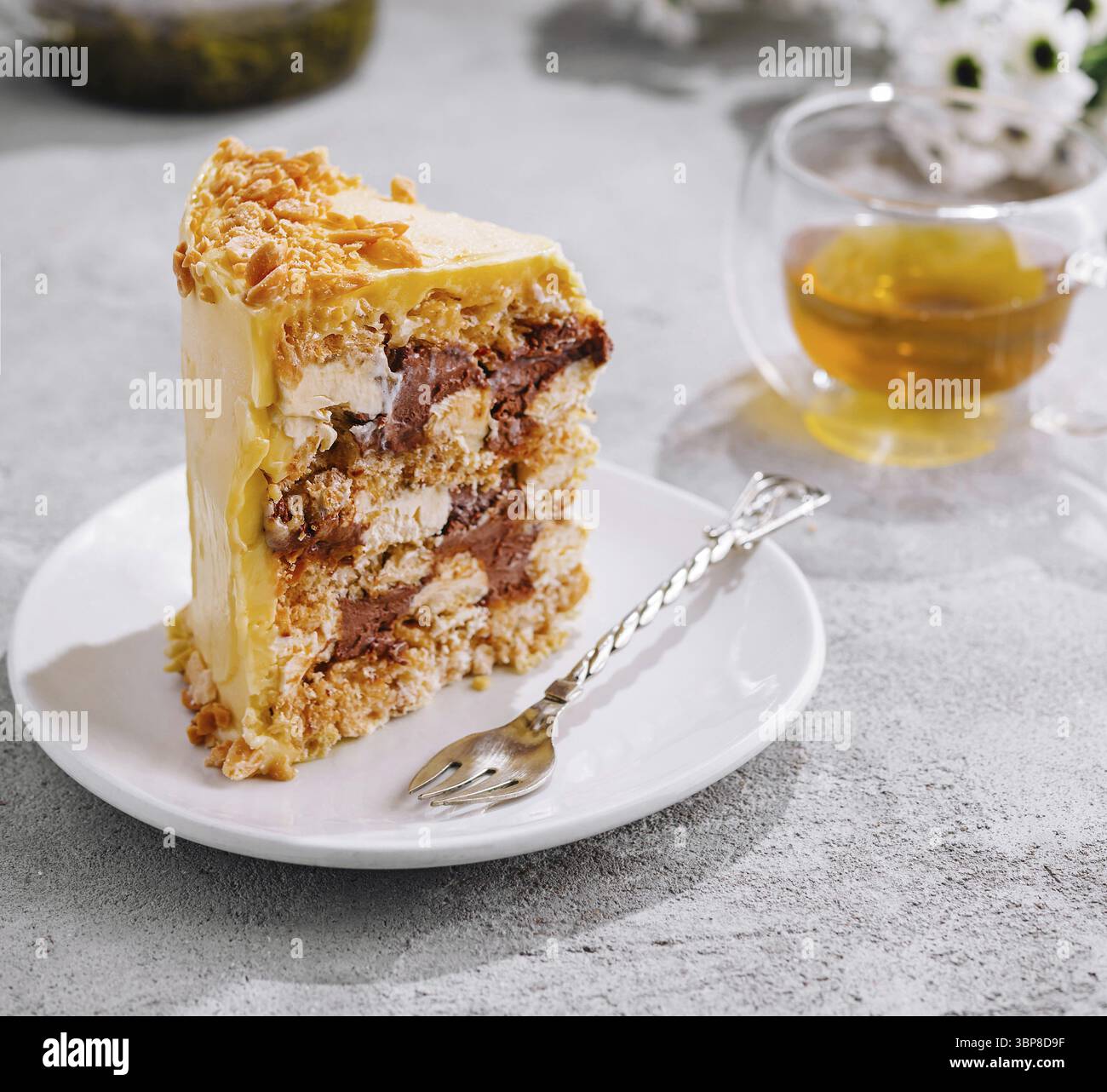 Essen, mehrschichtiger Honigkuchen, serviert auf einem weißen Teller, begleitet von Tee Stockfoto