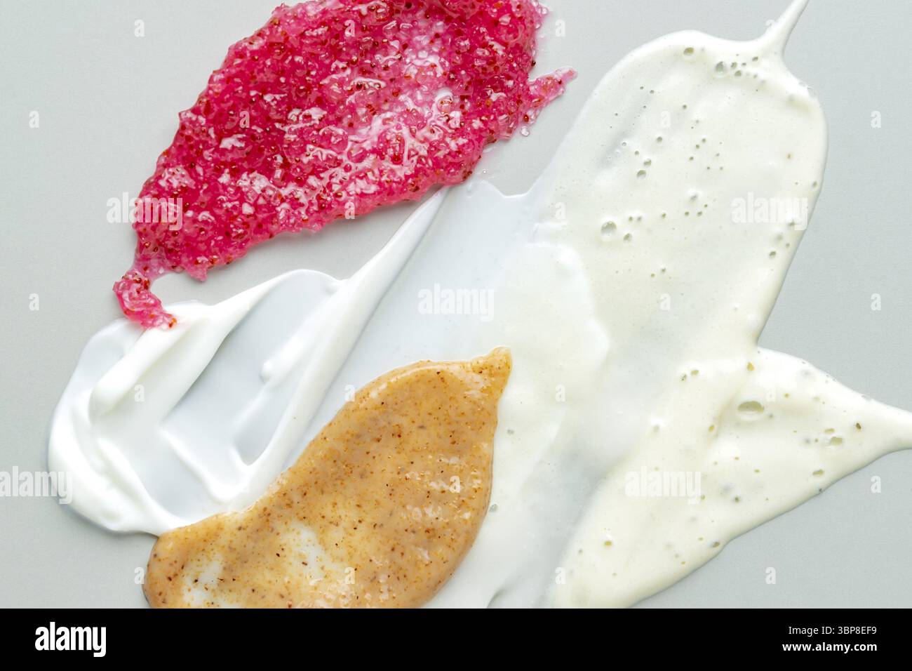 Weiße Salicylsäure Reiniger, Gesichtsmaske, Peeling-Textur. Exfoliant Gesichtswaschmousse verschmiert auf pastellgrauem Hintergrund Stockfoto