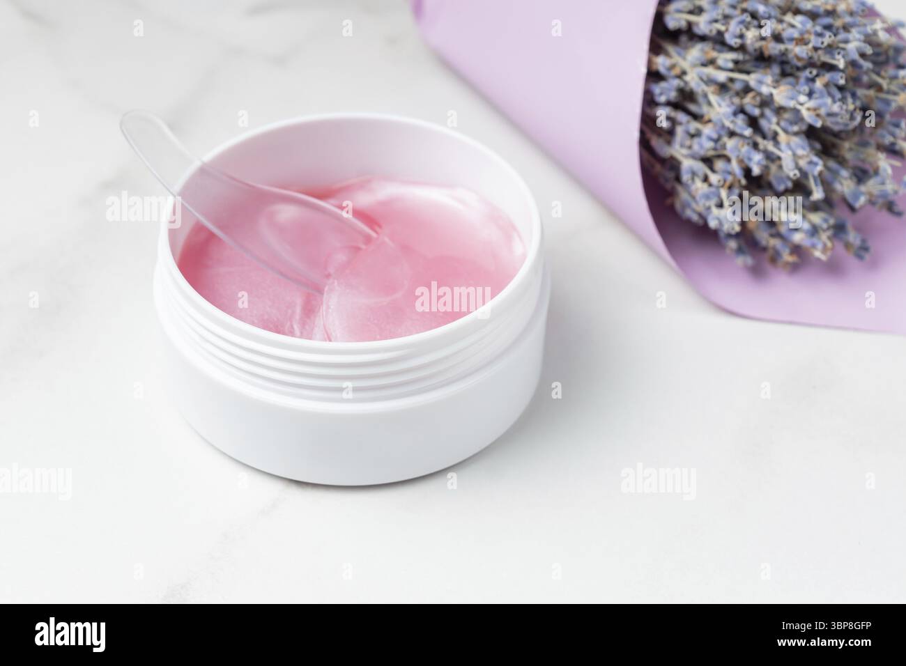 Rosa Augenflecken zur Reduzierung von Schwellungen und Blutergüssen unter den Augen mit einer Verpackung und einem Bouquet von trockenem Lavendel. Hausgemachte Gesichtspflege. Natürliches organisches cosme Stockfoto