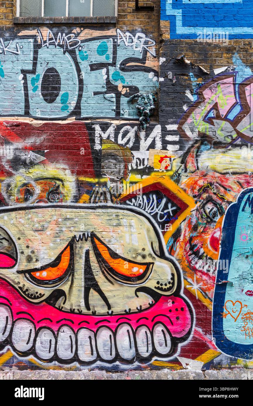 Farbenfrohe Wandgemälde an einer Backsteinmauer an der Ecke Buxton Street und Brick Lane im East End, einem berühmten kulturellen Wahrzeichen in London, Großbritannien Stockfoto