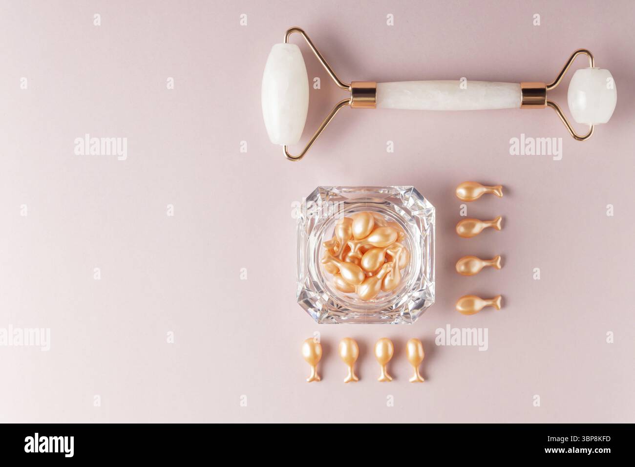 Pink Quarts Gesichtswalze und Serumkapseln mit Einzeldosis in einer Packung. Gesichtsmassage. Behandlung von Naturkosmetik. Monochromatischer Look, Knollenkonzept Stockfoto