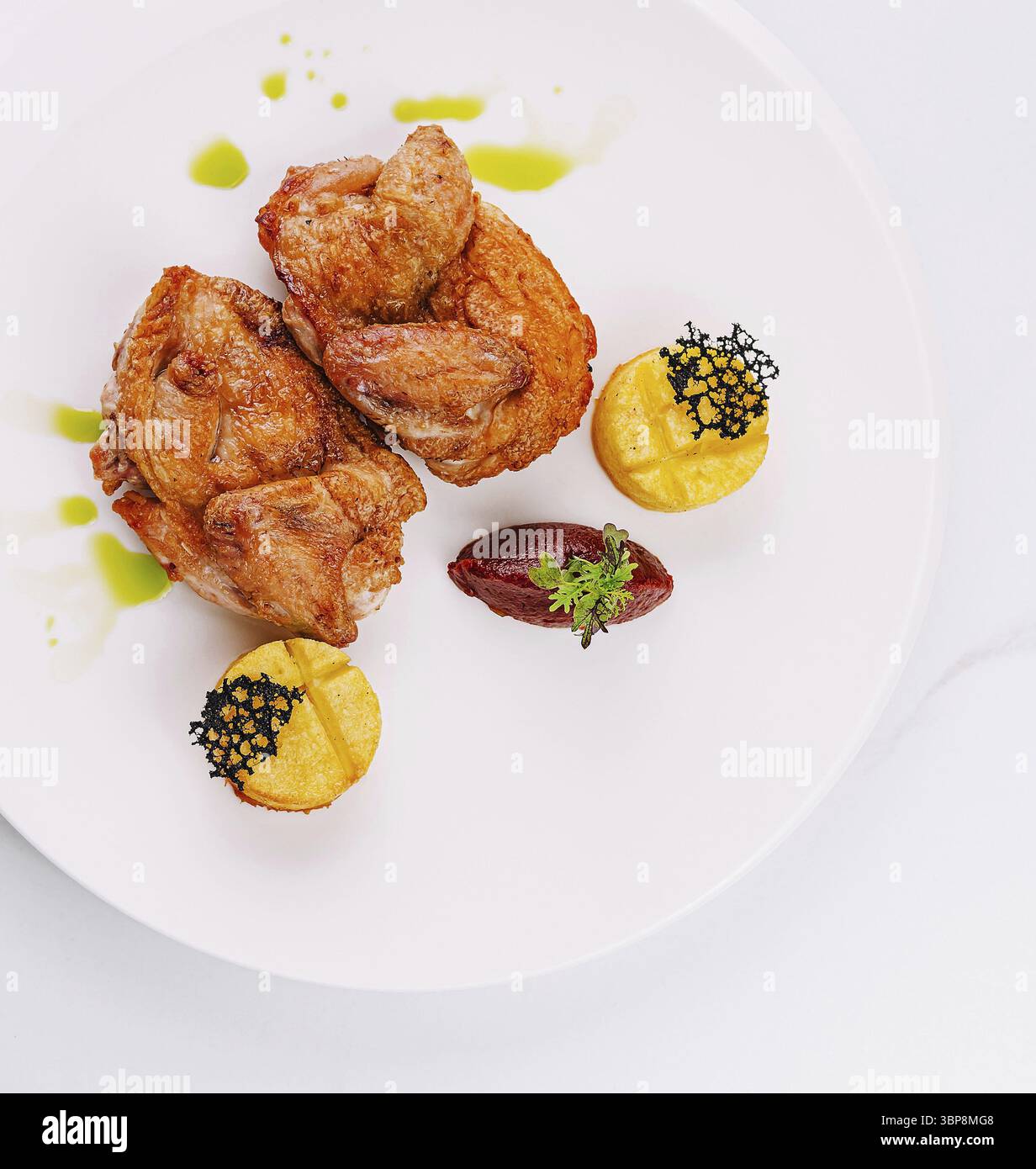 Essen, elegante Platte mit gebratenem Hähnchen garniert mit Kaviar, serviert mit bunten Pürees Stockfoto