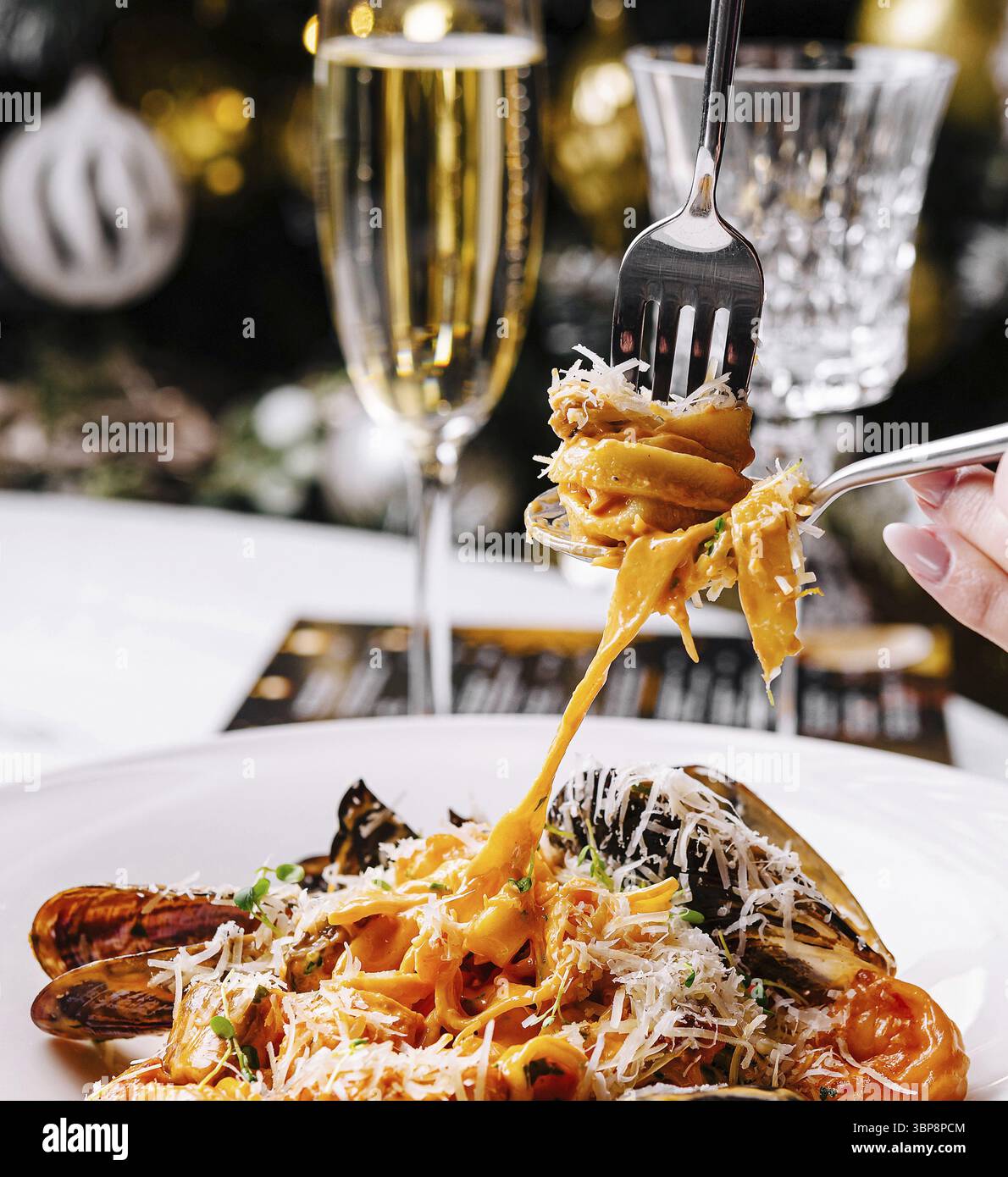 Essen, Nahaufnahme einer Gabel, die eine köstliche Pasta mit Meeresfrüchten garniert mit Käse dreht Stockfoto