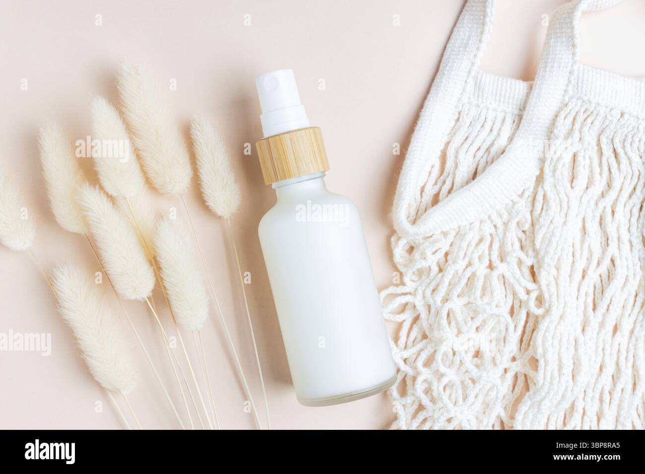 Anti-Aging-Kollagen-Gesichtscreme in einer Glasflasche mit trockenem Lagurusblatt auf beigem Hintergrund mit Kopierraum. Naturkosmetik Kosmetik-Konzept Stockfoto