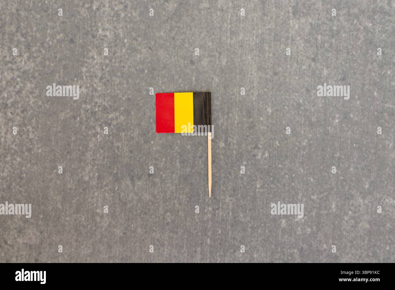 Mini Belgien Flagge auf Zahnstocher isoliert auf grauem Hintergrund Stockfoto