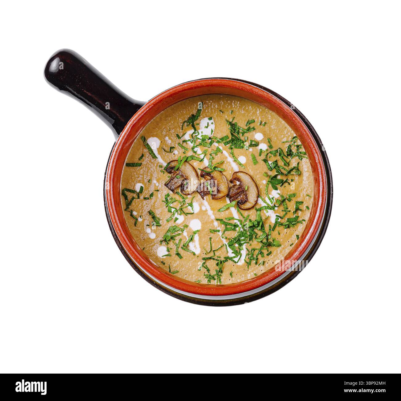 Speisen, cremige Pilzsuppe werden in einer rustikalen Schüssel serviert, garniert mit frischen Kräutern und einem Schuss Sahne Stockfoto