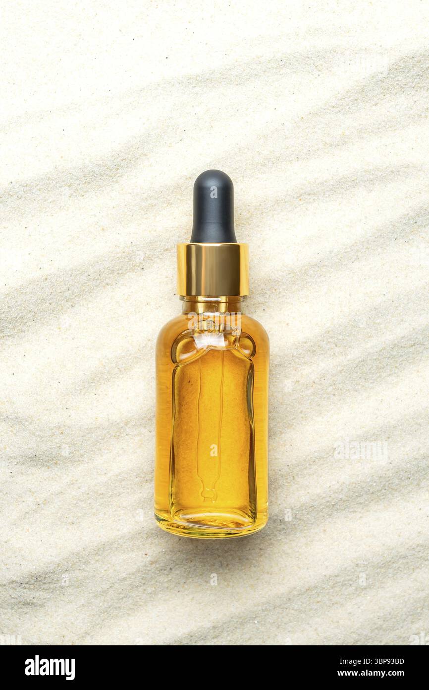 Hautpflege mit kosmetischem Gesichtsserum. Glasflasche mit Pipette auf natürlichem Hintergrund mit Sand. Hautpflegeprodukt für trockene Haut. Ätherisches Öl für Mois Stockfoto