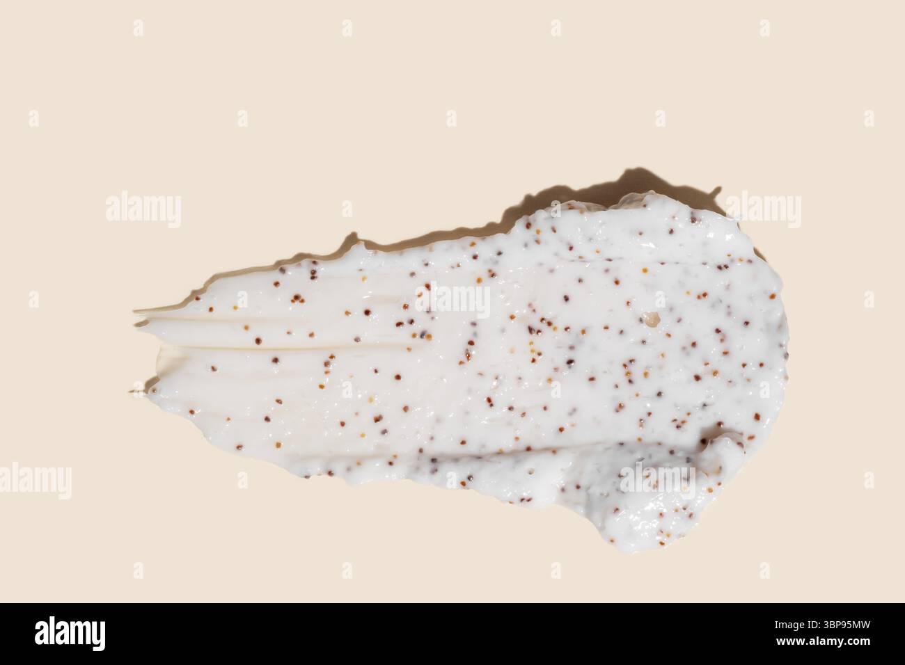 Streich von hausgemachtem Körperpeeling mit Kaffeekörnern auf beigefarbenem Hintergrund. Hautpflege-Peeling-Kosmetikpräsentation Stockfoto