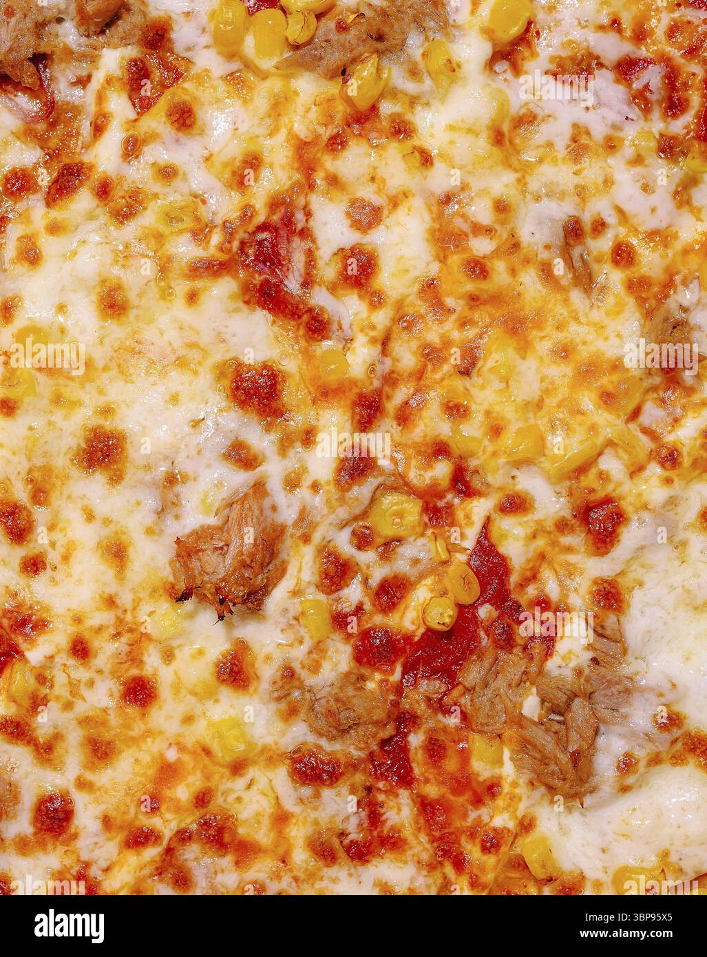 Essen, Eine köstliche Nahaufnahme von Pizza mit einer reichhaltigen Schicht Käse, herzhaftem Fleisch und süßem Mais. Die Beläge schaffen ein farbenfrohes und appetitliches A Stockfoto