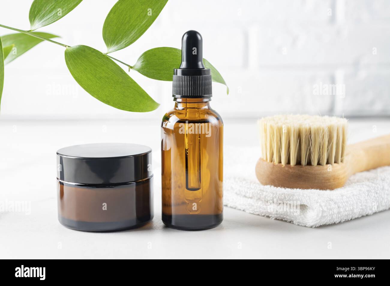Hautpflegeset mit Schönheitsöl, Gesichtscreme und Holzbürste mit Naturborsten für die Massage. Beauty Organic Behandlungskonzept Stockfoto