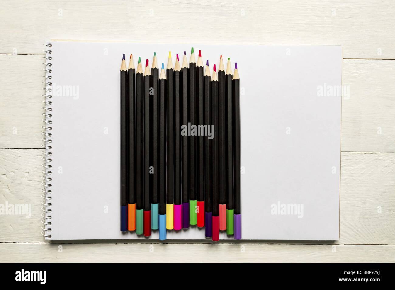 Farbstifte auf weißem Albumpapier. Draufsicht. Schul- und Bürobedarf Stockfoto