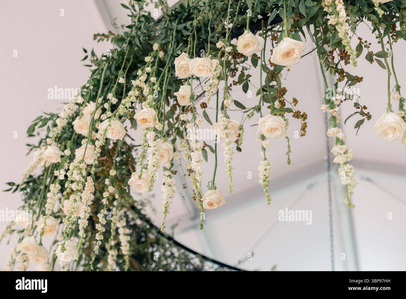 Kronleuchter mit Blumengrün und Hängeleuchten in weißem Zelt Stockfoto