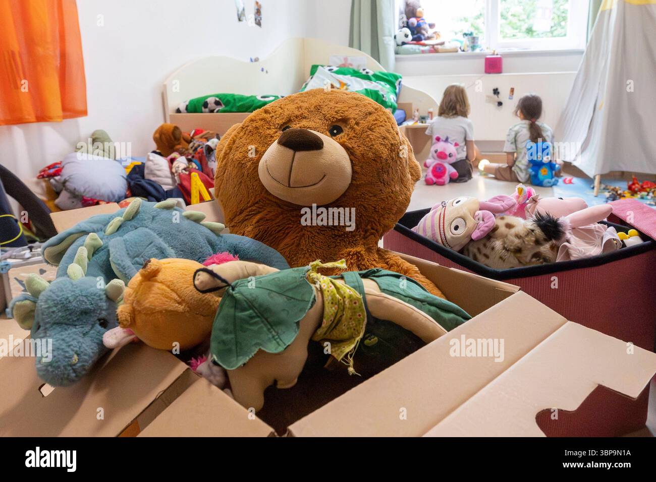Kinder in Kinderwohngruppe zwei Mädchen sitzen auf dem Boden einer Kinderwohngruppe im sächsischen Coswig. Symbolisch steht ein Karton mit Kuscheltieren vor den Kindern. Coswig Sachsen Deutschland *** Kinder in einer Kinderwohngruppe zwei Mädchen sitzen auf dem Boden einer Kinderwohngruppe in Coswig, Sachsen, Eine Schachtel mit Kuschelspielzeug steht symbolisch vor den Kindern Coswig Sachsen Deutschland Daniel Wagner Stockfoto
