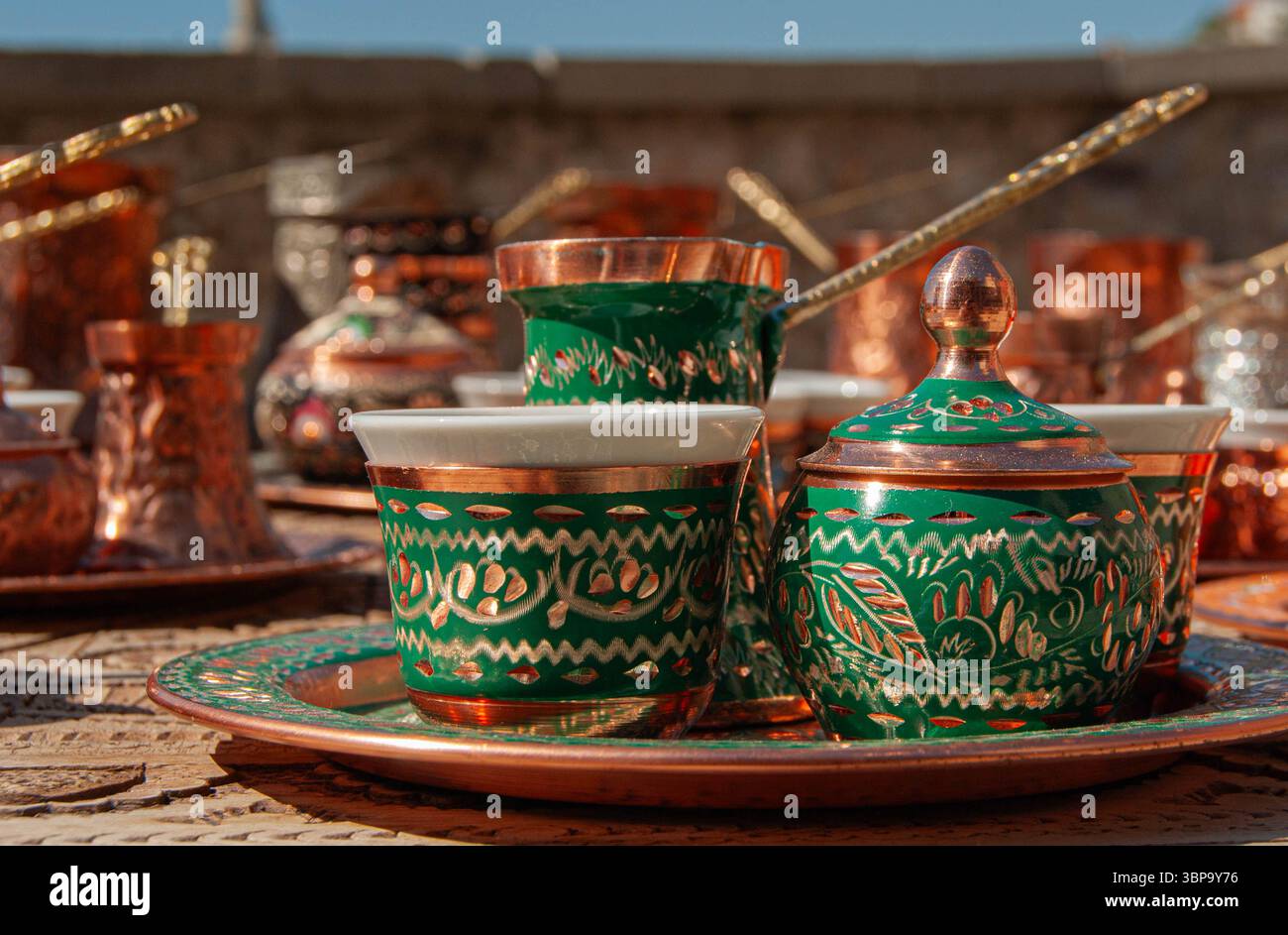 Traditionelle türkische Kupferkaffeekanne mit grüner Patina und passenden Tassen, bereit für die Zubereitung von reichhaltigem türkischem Kaffee. Stockfoto