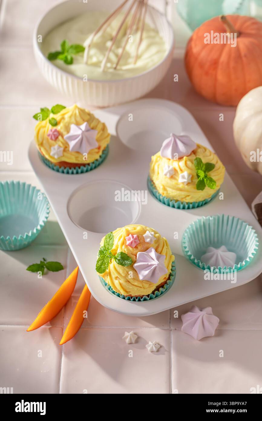 Vanillekürbis-Muffins mit Creme, Streuseln und Baisons. Dessert für Halloween. Stockfoto