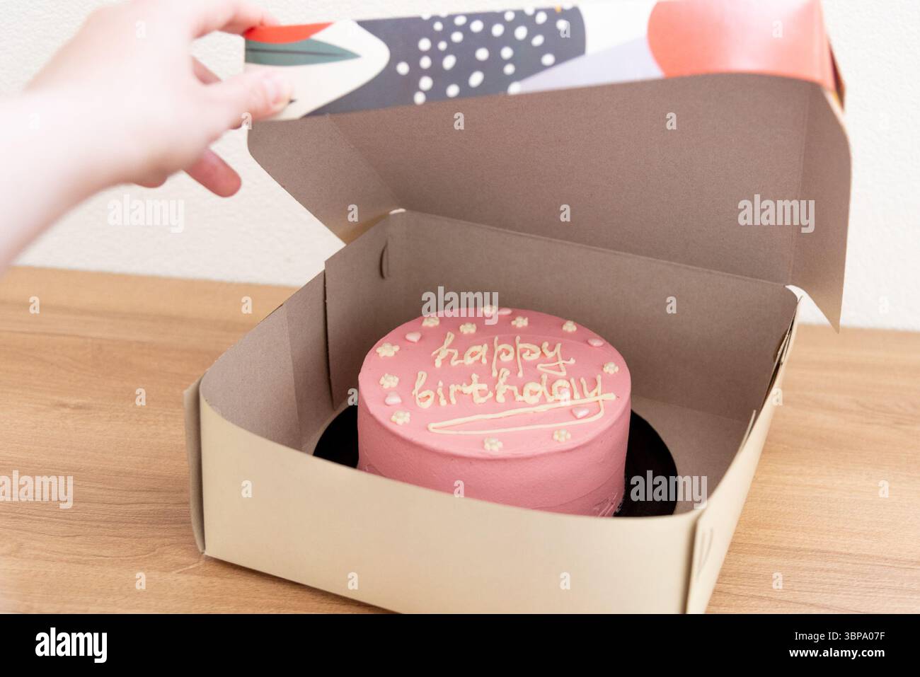 Pinkfarbene Haustorte mit einer Inschrift zum Geburtstag eines Mädchens, drei Jahre alt Stockfoto