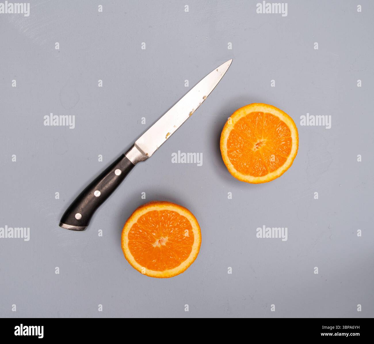 Schneiden Sie Orangen mit Orangensaft als flache Platte von oben nach unten. Kithen-Messer Stockfoto