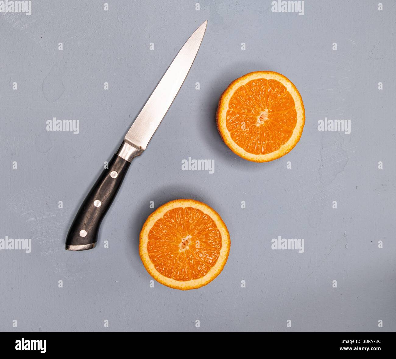 Schneiden Sie Orangen mit Orangensaft als flache Platte von oben nach unten. Kithen-Messer Stockfoto