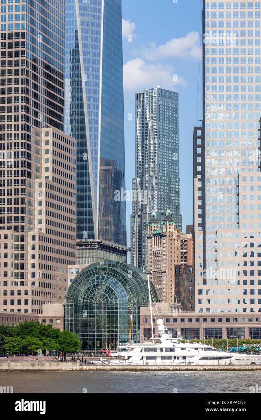 Blick auf Lower Manhattan und das World Financial Center und seinen Wintergarten, vor dem eine Luxusyacht vertäut ist Stockfoto