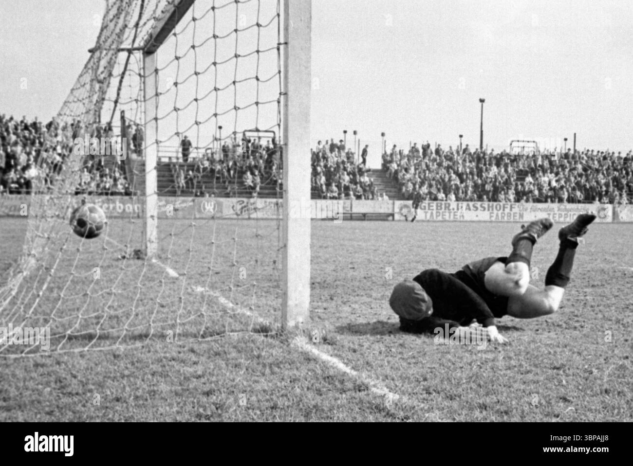 60er Jahre, Sport, Fußball, Regionalliga West, 1964/1965, 11.04.1965, Sportfreunde Hamborn 07 gegen Borussia Mönchengladbach 1:3, August Thyssen Stadion in Duisburg-Bruckhausen, Tor zu Gladbach, Torhüter Franz Josef Sarna (07) wird geschlagen Stockfoto