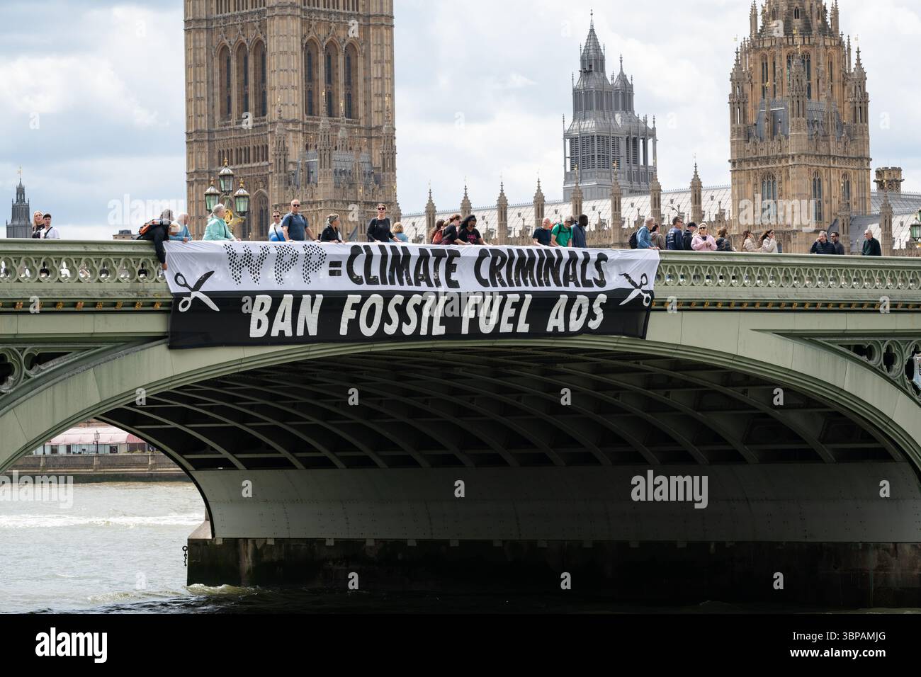 London, Großbritannien. 7. Juli 2025. Klimaaktivisten lassen ein Banner von der Westminster Bridge fallen, mit den Houses of Parliament im Hintergrund, vor einer Debatte der Abgeordneten über eine Petition zum Verbot von Werbung und Sponsoring für fossile Brennstoffe. Die Petition, die vom Naturforscher, Fernsehmoderator und Autor Chris Packham aufgeworfen wurde, erhielt über 100.000 Unterschriften und sagt, dass der fortgesetzte Verbrauch fossiler Brennstoffe mehr Menschen töten wird als das Rauchen, für das 2002 Werbung verboten wurde. Quelle: Ron Fassbender/Alamy Live News Stockfoto