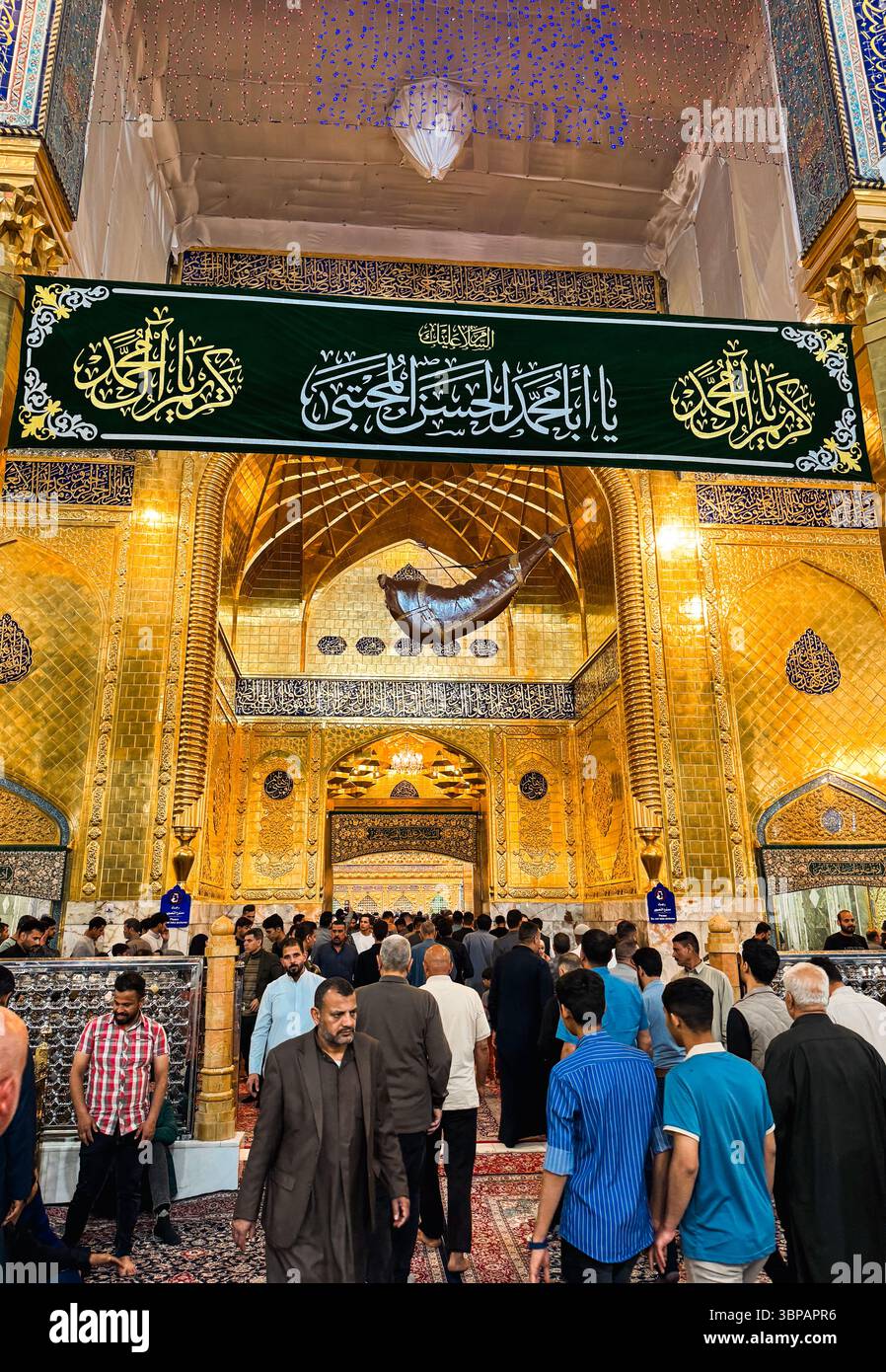 Pilger strömen zum verehrten Schrein in Karbala, Irak, und nehmen an spiritueller Hingabe und Reflexion Teil, die mit kunstvollen Dekorationen geschmückt sind. Stockfoto