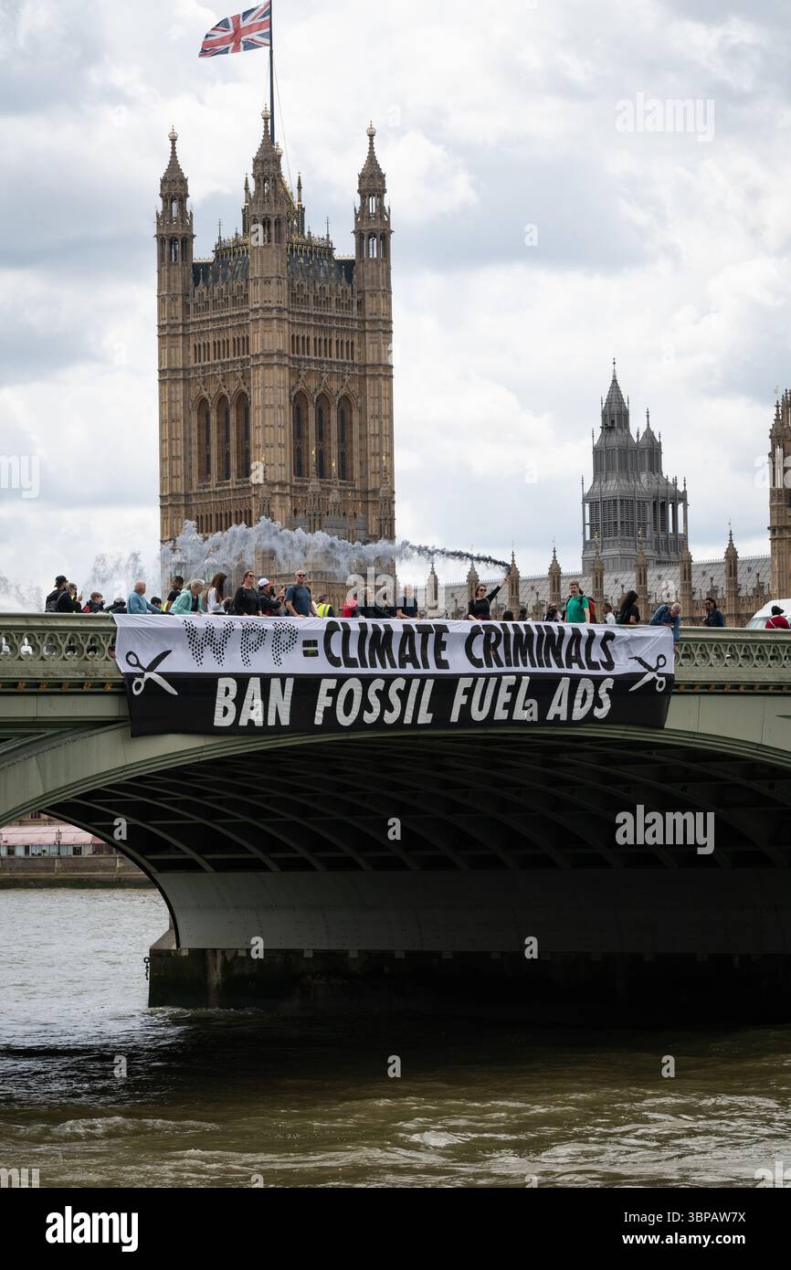 London, Großbritannien. 7. Juli 2025. Klimaaktivisten lassen ein Banner von der Westminster Bridge fallen, mit den Houses of Parliament im Hintergrund, vor einer Debatte der Abgeordneten über eine Petition zum Verbot von Werbung und Sponsoring für fossile Brennstoffe. Die Petition, die vom Naturforscher, Fernsehmoderator und Autor Chris Packham aufgeworfen wurde, erhielt über 100.000 Unterschriften und sagt, dass der fortgesetzte Verbrauch fossiler Brennstoffe mehr Menschen töten wird als das Rauchen, für das 2002 Werbung verboten wurde. Quelle: Ron Fassbender/Alamy Live News Stockfoto