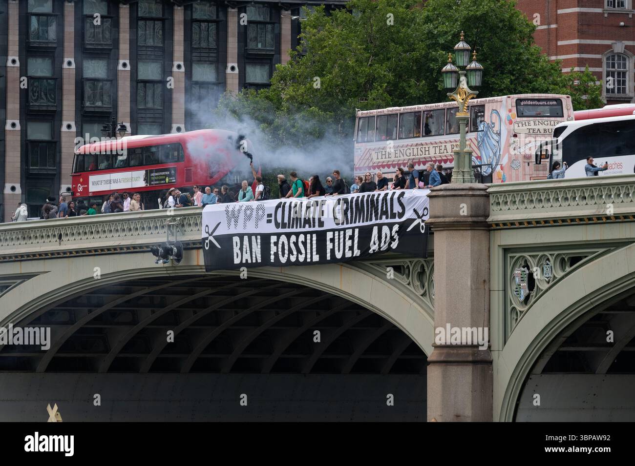 London, Großbritannien. 7. Juli 2025. Klimaaktivisten lassen ein Banner von der Westminster Bridge fallen, mit den Houses of Parliament im Hintergrund, vor einer Debatte der Abgeordneten über eine Petition zum Verbot von Werbung und Sponsoring für fossile Brennstoffe. Die Petition, die vom Naturforscher, Fernsehmoderator und Autor Chris Packham aufgeworfen wurde, erhielt über 100.000 Unterschriften und sagt, dass der fortgesetzte Verbrauch fossiler Brennstoffe mehr Menschen töten wird als das Rauchen, für das 2002 Werbung verboten wurde. Quelle: Ron Fassbender/Alamy Live News Stockfoto