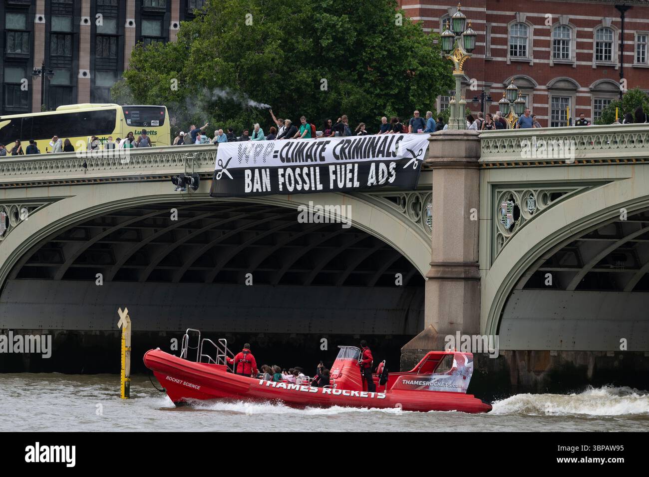 London, Großbritannien. 7. Juli 2025. Klimaaktivisten lassen ein Banner von der Westminster Bridge fallen, mit den Houses of Parliament im Hintergrund, vor einer Debatte der Abgeordneten über eine Petition zum Verbot von Werbung und Sponsoring für fossile Brennstoffe. Die Petition, die vom Naturforscher, Fernsehmoderator und Autor Chris Packham aufgeworfen wurde, erhielt über 100.000 Unterschriften und sagt, dass der fortgesetzte Verbrauch fossiler Brennstoffe mehr Menschen töten wird als das Rauchen, für das 2002 Werbung verboten wurde. Quelle: Ron Fassbender/Alamy Live News Stockfoto