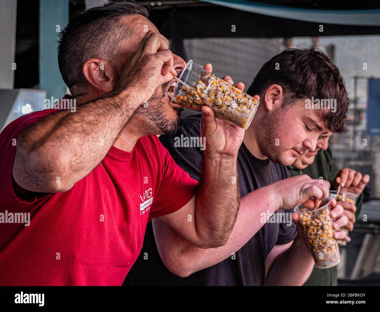 Die Teilnehmer nehmen am Wettbewerb „Eat a Pint of Cocoles“ an der Old Leigh Regatta in Leigh on Sea Teil. Stockfoto