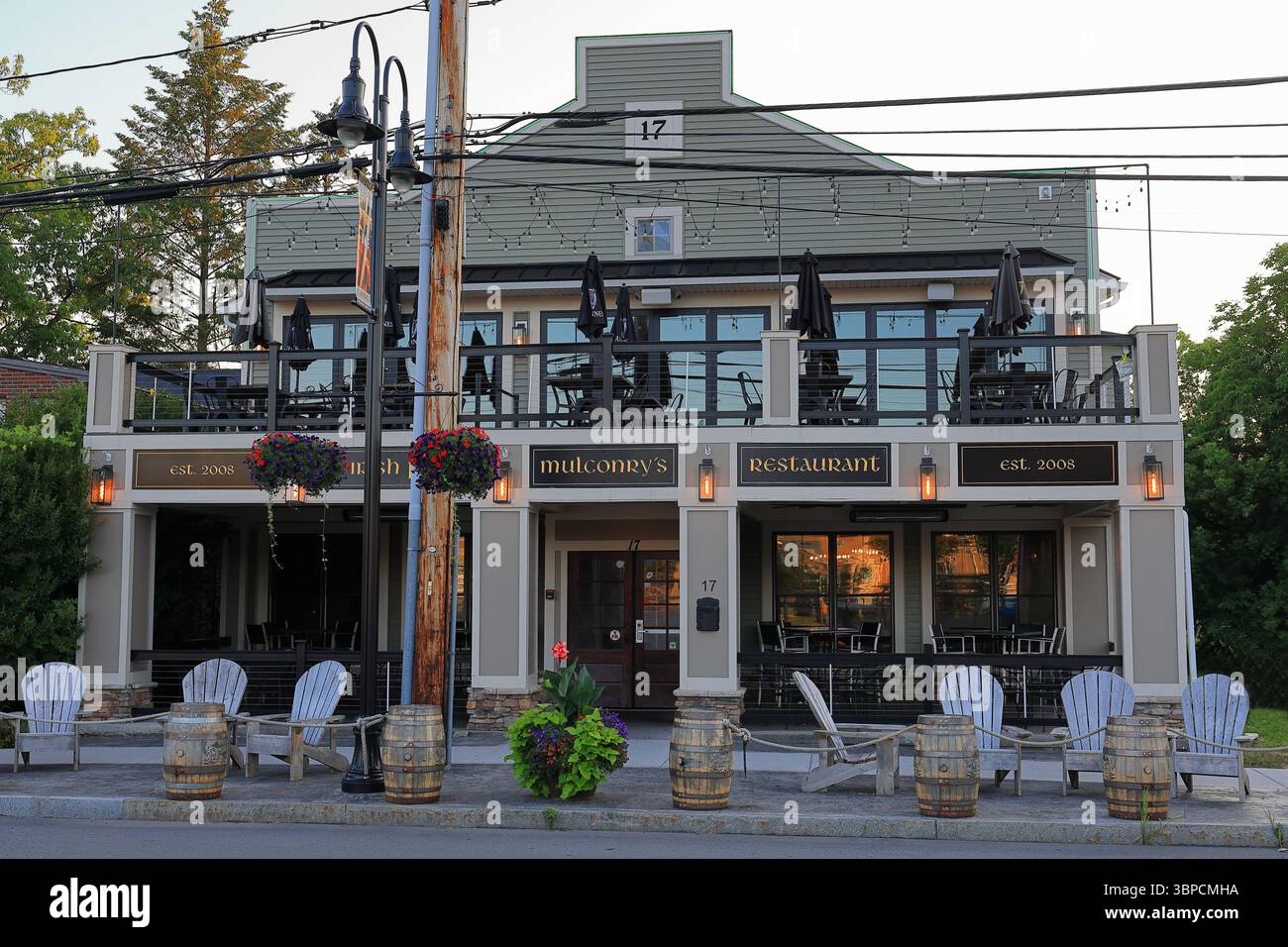 Fairport, NY, USA - 2. Juli 2025 - Mulconry's Irish Pub im Dorf Fairport, der die roten und orangen Strahlen der Sonne im Morgenlicht reflektiert. Stockfoto