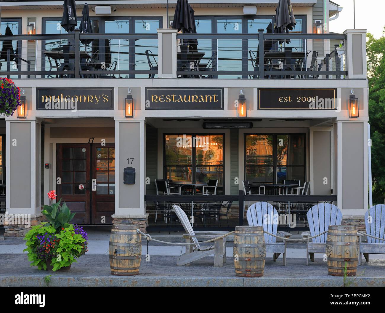 Fairport, NY, USA - 2. Juli 2025 - Mulconry's Irish Pub im Dorf Fairport, der die roten und orangen Strahlen der Sonne im Morgenlicht reflektiert. Stockfoto