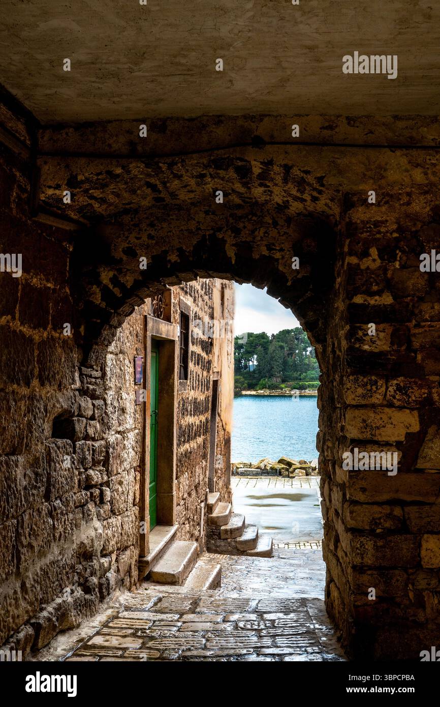 Bogengang aus Stein von der Altstadt zum Hafen in Rovinj, Kroatien. Stockfoto