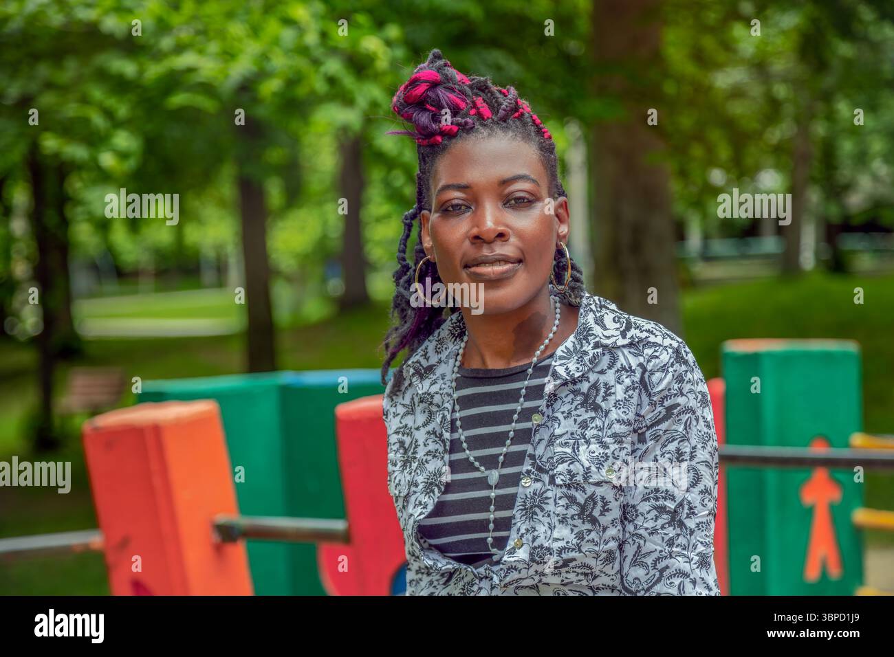 Schwarze Frau genießt friedliche Momente auf farbenfroher Parkbank, umgeben von Natur. Perfekt für Lifestyle, Wellness, Entspannung, Erholung im Freien, Männer Stockfoto