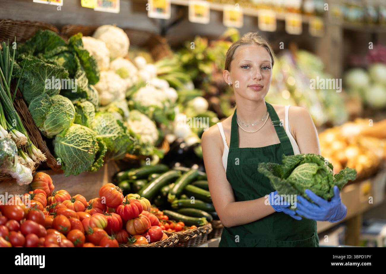 Weibliche Lebensmittelläden bieten Reifen Brokkoli-Kohl in der Lebensmittelabteilung des Supermarktes an Stockfoto